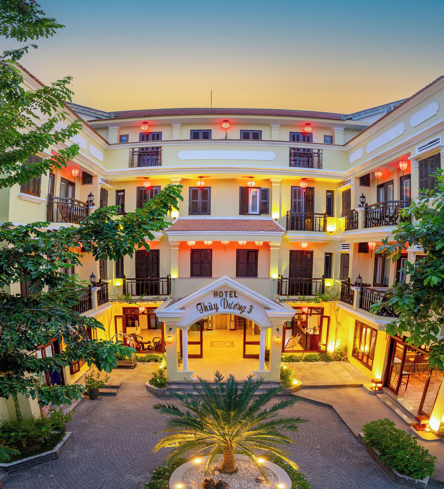 Un hotel con patio central, varios balcones y detalles arquitectónicos tradicionales.