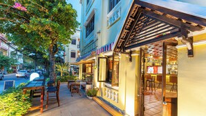 Un restaurant avec une terrasse, un sol carrelé et une vue sur la rue.
