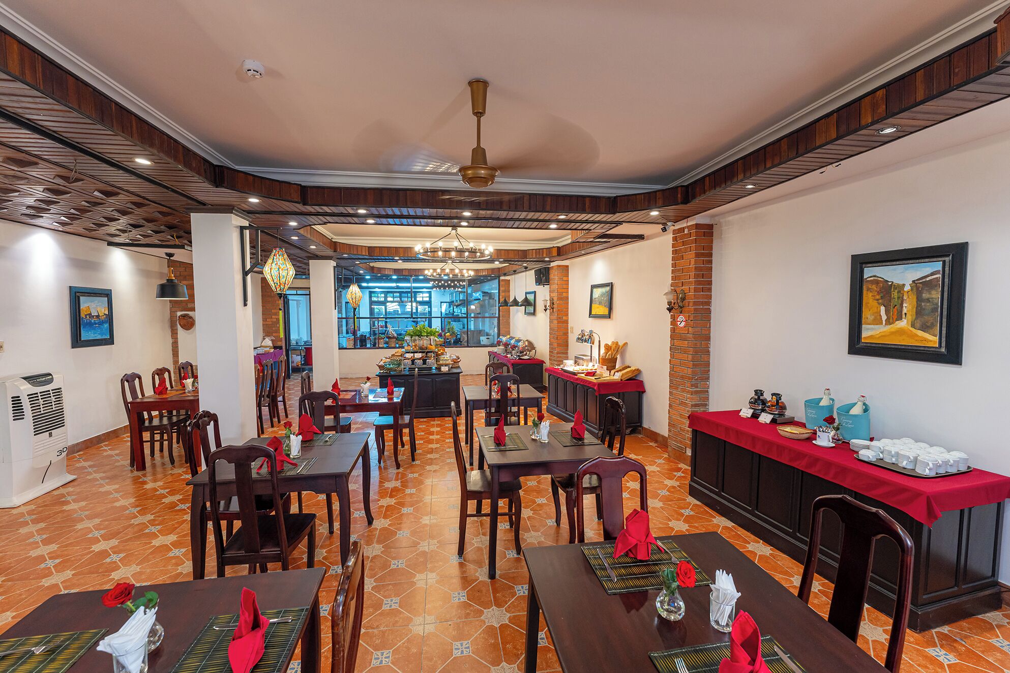 Un restaurante con varias mesas, una zona de buffet y vistas a la calle a través de amplias ventanas.