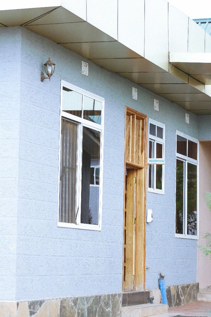 A building with a reception area, a wooden door, and a window with a curtain.