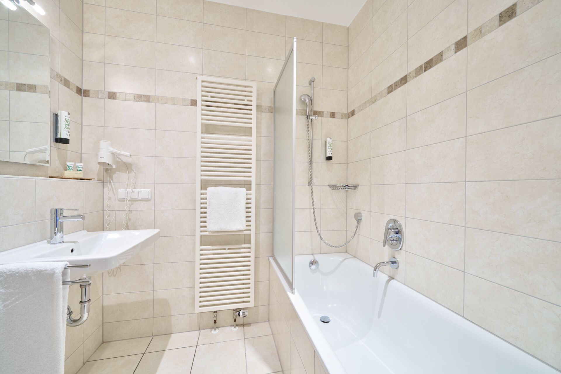 A modern bathroom with a white bathtub, a separate shower area, and a vanity with a sink.