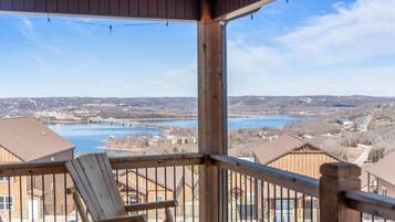 A wooden deck with a view of a lake and surrounding buildings.