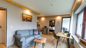 En hyggelig stue med en sofa, et sofabord og et billede på væggen.