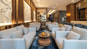 A modern hotel lobby with a central seating area, a reception desk, and a decorative wall with a unique design. - Hotel Riu Plaza Chicago (Chicago)