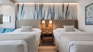 A hotel room with two beds, a wooden nightstand, and a wall-mounted lamp.
