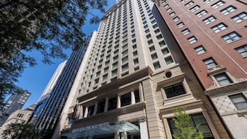 Un hotel de gran altura con un diseño arquitectónico clásico, que presenta una entrada destacada con un toldo de cristal y un letrero del HOTEL RIVIERA CHICAGO.