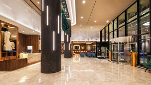 A spacious lobby with a marble floor, a reception desk, and a glass partition. - Hotel Riu Plaza Chicago (Chicago)