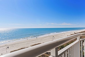 A beach view from a balcony with a railing, ocean, and beachgoers. - 3 Bdrm Oceanfront Condo- 4 Bds- Pool- Near Main St (North Myrtle Beach)