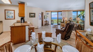 A spacious dining area with a bar, wicker furniture, and a view of the ocean.