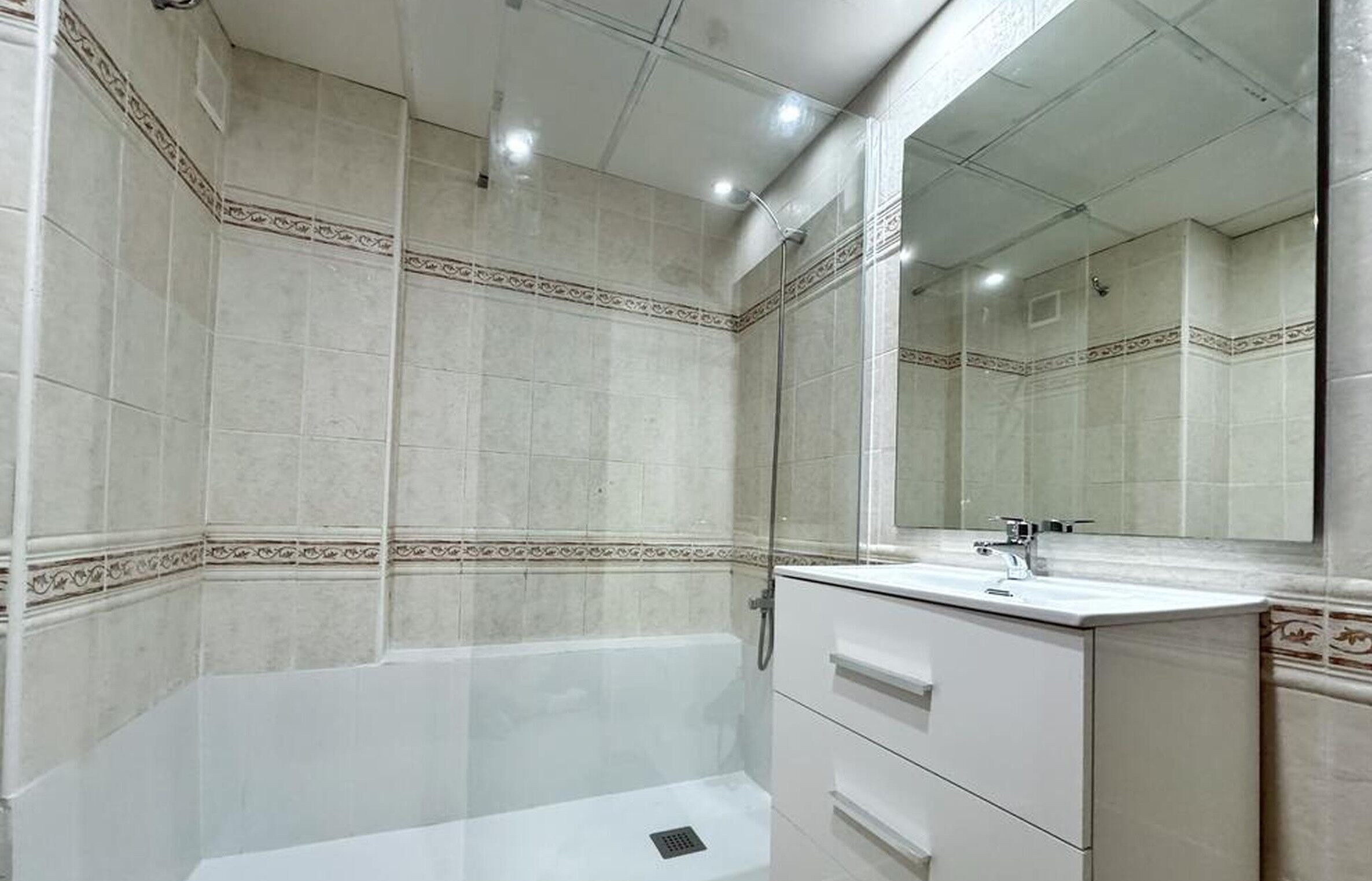 Un baño con bañera, lavamanos y espejo.