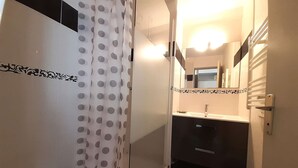 Une salle de bain avec une douche, un lavabo et des toilettes.