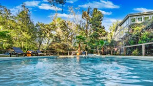A swimming pool surrounded by trees and a building. - Coastal Charm in the Heart of Hilton Head Island (Hilton Head Island)
