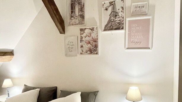 A bedroom with a bed, pillows, a nightstand, a lamp, and wall decorations including framed pictures and a quote. - Chambre Triple Avec Salle de Bains Privative à 10 Minutes de Disneyland Paris (Couilly-Pont-aux-Dames)