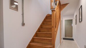A wooden staircase with a handrail leading to a landing. - The Duckhouse (Shrewsbury)
