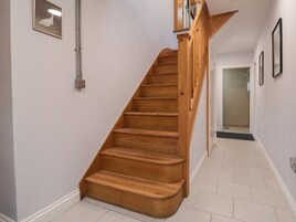 Una escalera de madera con barandilla que lleva a una plataforma.
