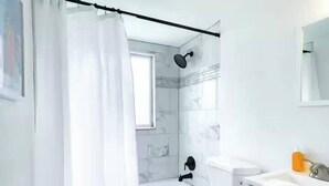 Ein Badezimmer mit Toilette, Waschbecken und Duschbereich.