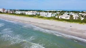 A beach with buildings in the background. - Fillmore Unit #1 | 2BR/1BA (Cape Canaveral)