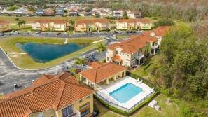 A residential area with a swimming pool, a small lake, and a parking lot. - Spacious & clean cozy home near Disney 448 (Davenport)