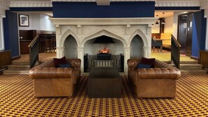 A grand lobby with a fireplace, leather sofas, and patterned carpet. - The Aberdeen Dyce Hotel (Aberdeen)