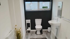 Une salle de bain moderne avec des toilettes, un lavabo et une fenêtre.
