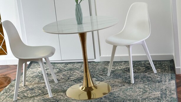 A dining area with a glass table and two white chairs, a small plant on the table, and a hexagonal planter on the wall. - 1 bedroom apartment in ercolano (Ercolano)