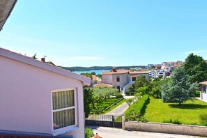 Un quartier résidentiel avec des maisons, un ciel dégagé et une étendue d’eau visible au loin.