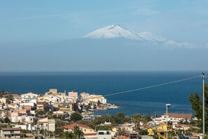 A coastal town with a snow-capped mountain in the background. - Etna Mare Apartments by Wonderful Italy (Augusta)