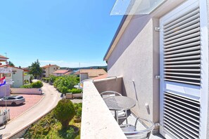 Enjoy a balcony with a table and chairs, offering a view of the surrounding neighborhood.