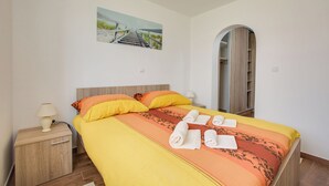 Ein Hotelzimmer mit Bett, zwei Nachttischen, einem Spiegel und einem Bild an der Wand.