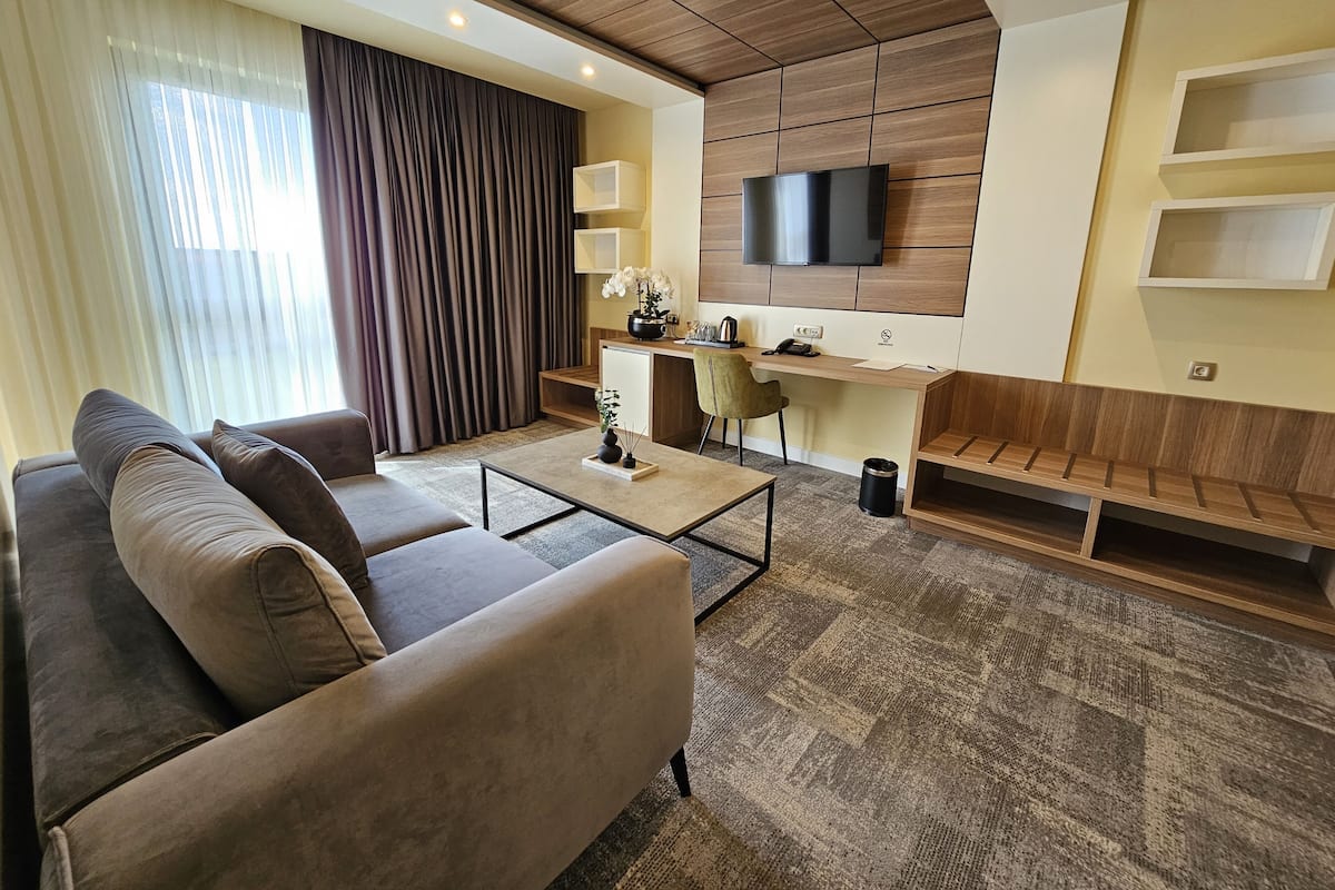 Ein modernes Wohnzimmer mit einer Couch, einem Couchtisch und einem an der Wand befestigten Fernseher.