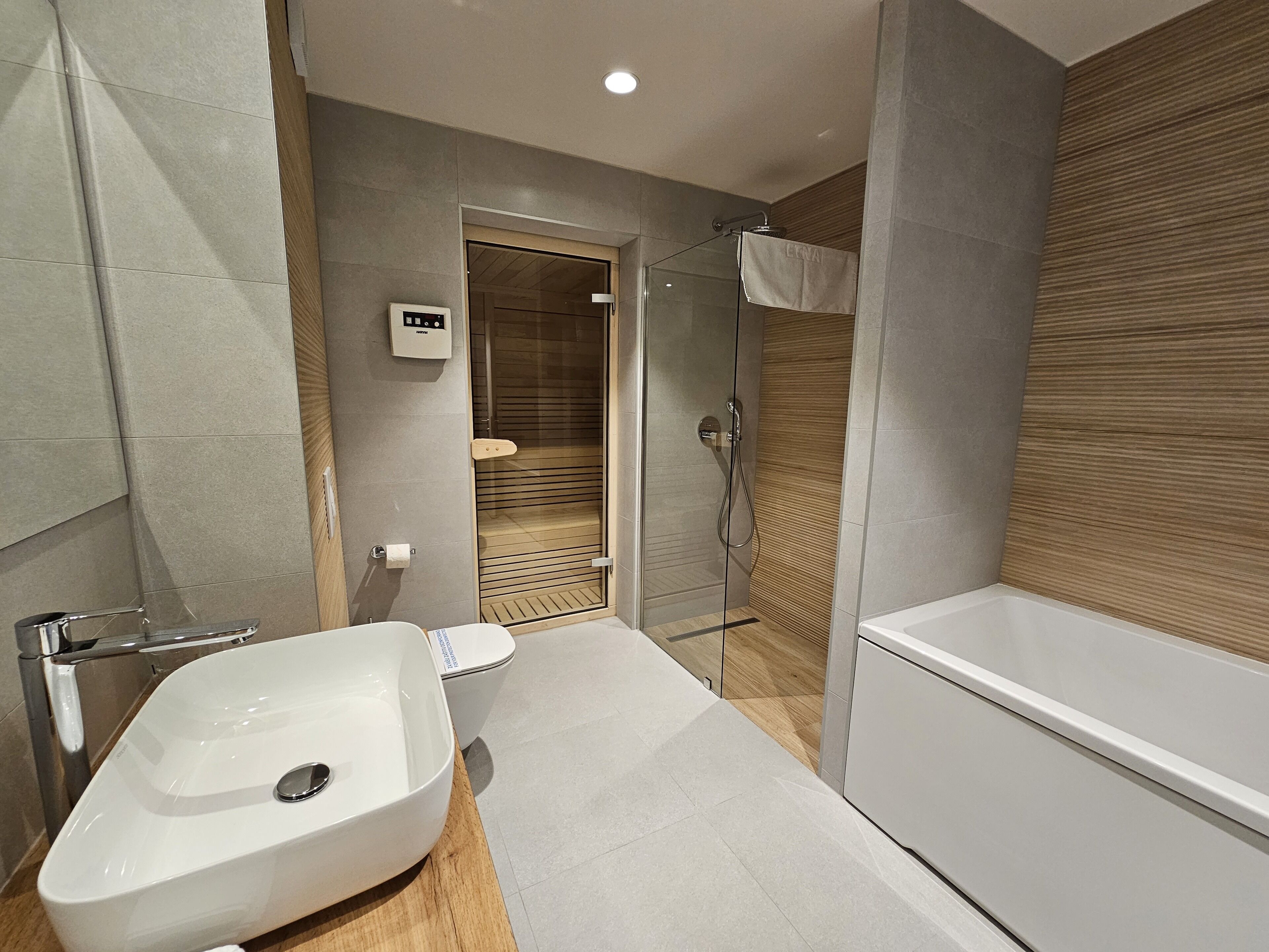 A modern bathroom with a large white bathtub, a separate shower area, and a vanity with a sink.