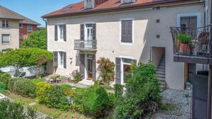 A two-story building with a balcony, a small garden, and a staircase leading to the upper floor. - Venez Chez Vous La Maison des Balmettes (Annecy)