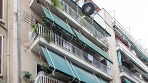 A multi-story building with balconies, awnings, and a parked car. - Ano Kipseli Athens Gem 1 Bd Apt for 4 (Athens)