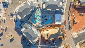 Eine Vogelperspektive zeigt ein Hotel mit mehreren Gebäuden, einem Pool und einem Parkplatz.