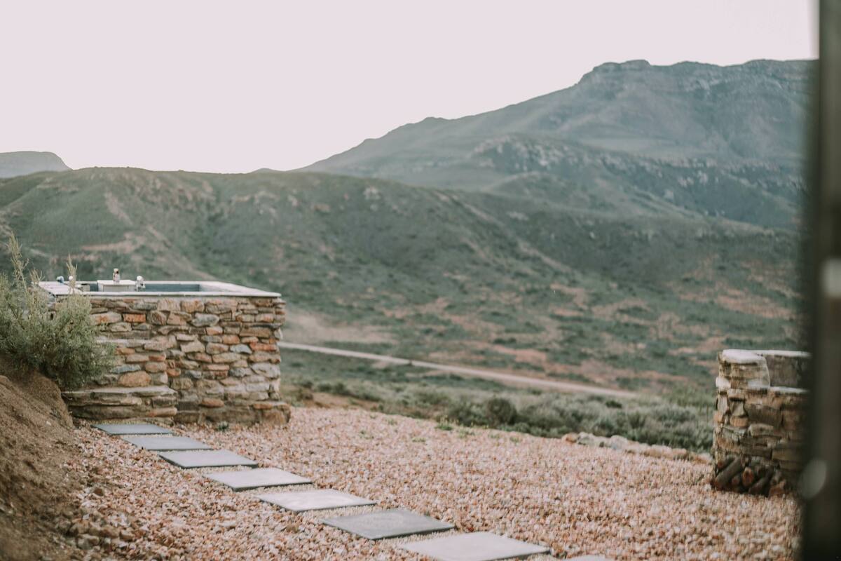A stone structure with a pathway leading to a mountainous landscape.