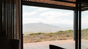Una habitación con un gran ventanal que ofrece vistas a un paisaje montañoso.