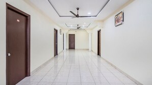A hallway with a ceiling fan, recessed lighting, and a tiled floor. - iROOMZ Hotel Ritzy Grand (Hyderabad)