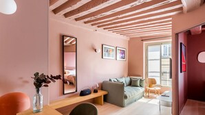 Ein modernes Wohnzimmer mit Holzbalkendecke, einer Couch, einem Couchtisch und einem Spiegel.
