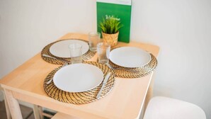 Une table dressée avec des assiettes blanches, des verres transparents et un set de table en fibres tressées.