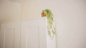 Une armoire blanche avec une plante suspendue.
