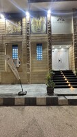 A hotel entrance with a stone facade, a large Egyptian-themed mural, and a sign for Pyramids Hotel.