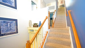A staircase with wooden handrails and carpeted steps leading to an upper floor.