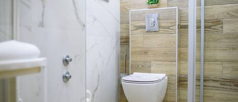 Une salle de bain avec des toilettes, une douche et un lavabo.