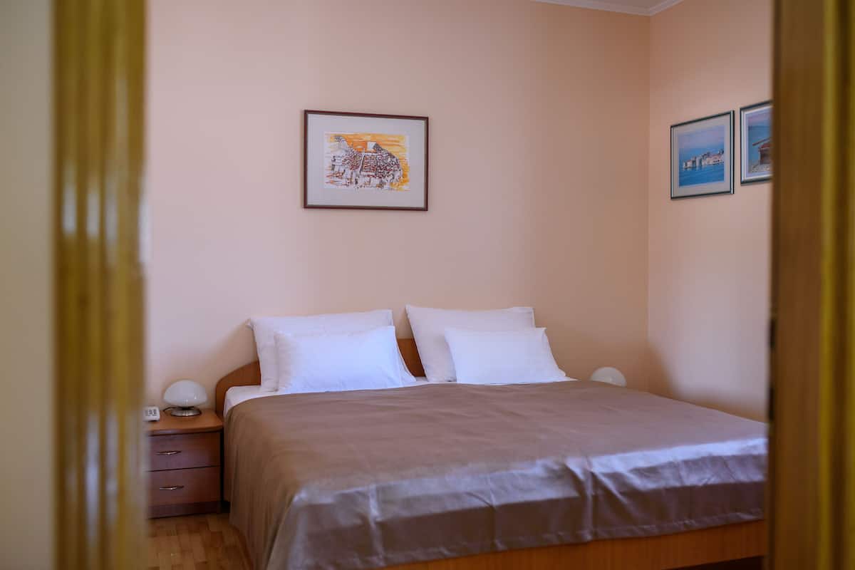 A bedroom with a bed, two bedside tables, and a nightstand.