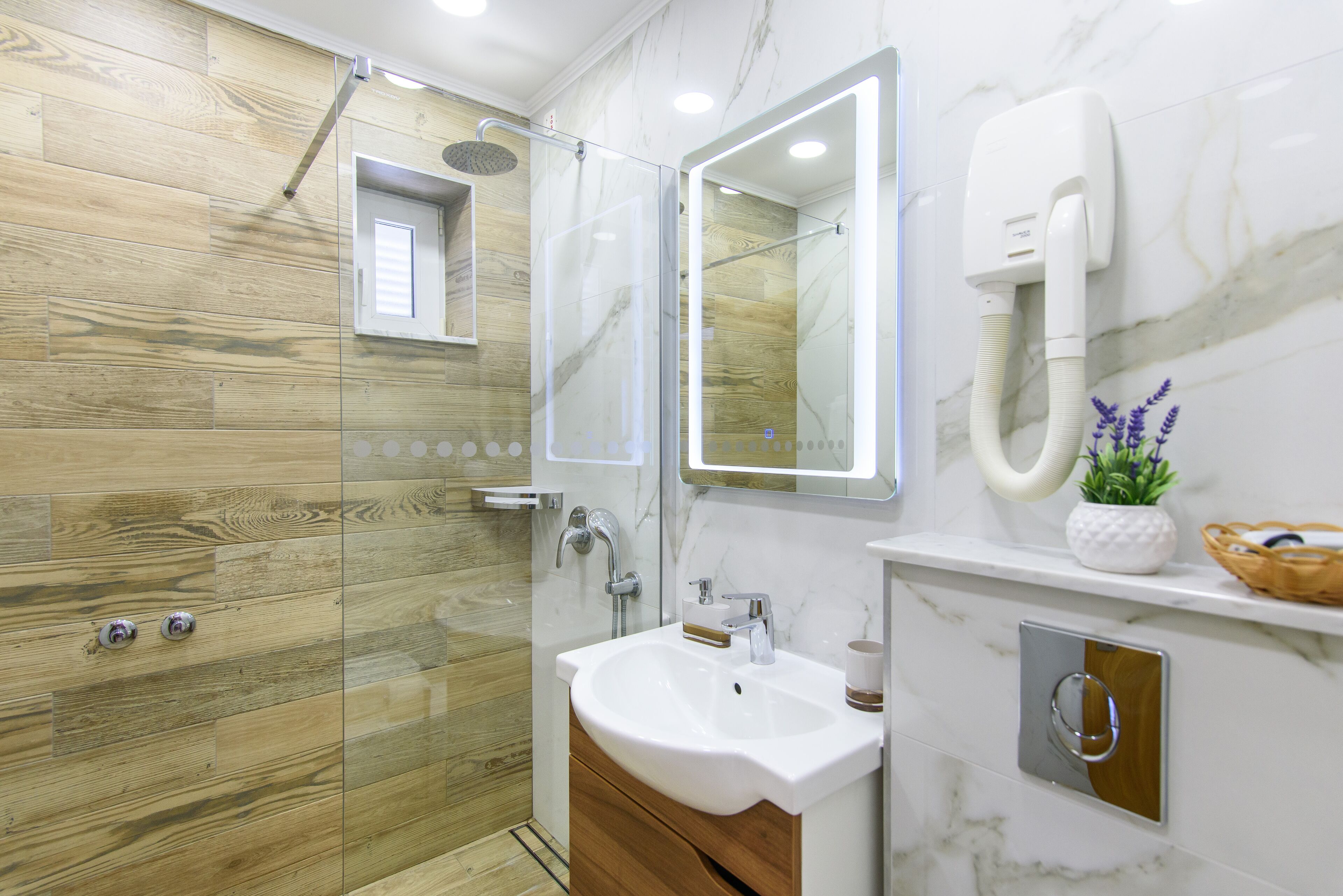 A modern bathroom with a shower, a sink, and a mirror.