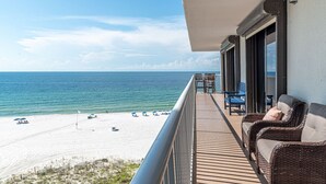 A balcony with wicker furniture overlooking a beach. - Oceanfront 3BR w/ Incredible Views+Balcony+Pools (Orange Beach)