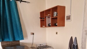 Una cocina compacta con estufa a gas, un lavamanos y una pequeña encimera.