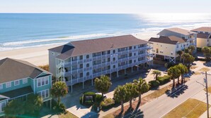 A beachfront hotel with multiple balconies, a parking area, and a view of the ocean. - Oceanfront 2 BR Condo with a Shared Pool! Channel Marker 204 (Surfside Beach)