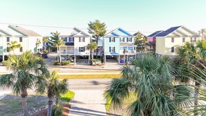 A row of single-story houses with attached porches, surrounded by palm trees. - 2nd Row 4 BR Beach House! Dream Weaver (Surfside Beach)