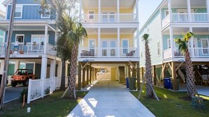 A beachfront hotel with two-story buildings, balconies, and a covered walkway.